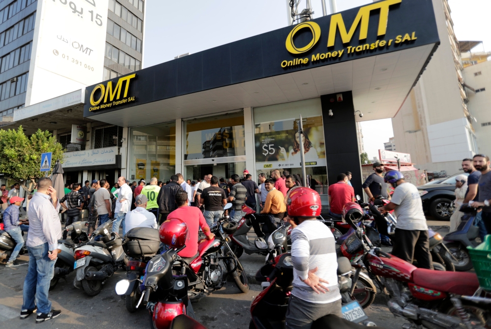 People gather at a shop that provides money transfer services in the Lebanese capital Beirut on November 9, 2019.  AFP / ANWAR AMRO
