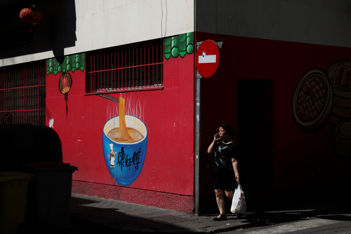 A woman walks past a Chinese food store at Usera district in Madrid, Spain, July 24, 2017. Reuters / Susana Vera