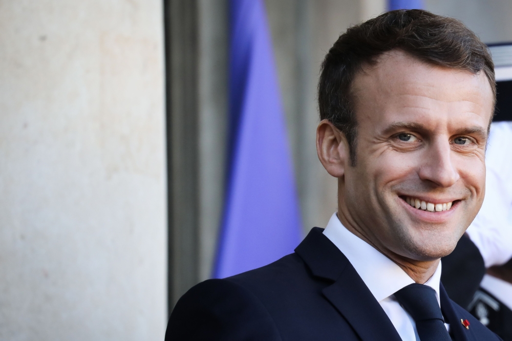 France's President Emmanuel Macron smiles as he waits for guests at the Elysee presidential palace prior to a working lunch as part of the Paris Peace Forum, on November 12, 2019 in Paris. / AFP / LUDOVIC MARIN