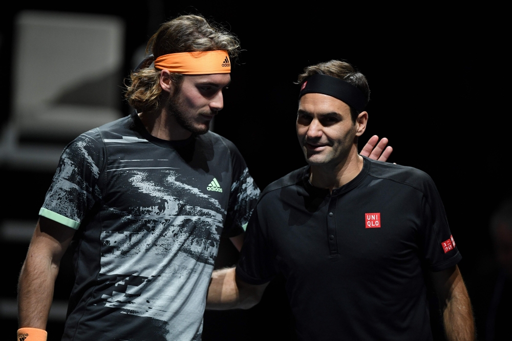 Greece's Stefanos Tsitsipas (L) and Switzerland's Roger Federer interact before the men's singles semi-final match on day seven of the ATP World Tour Finals tennis tournament at the O2 Arena in London on November 16, 2019. / AFP / Daniel LEAL-OLIVAS