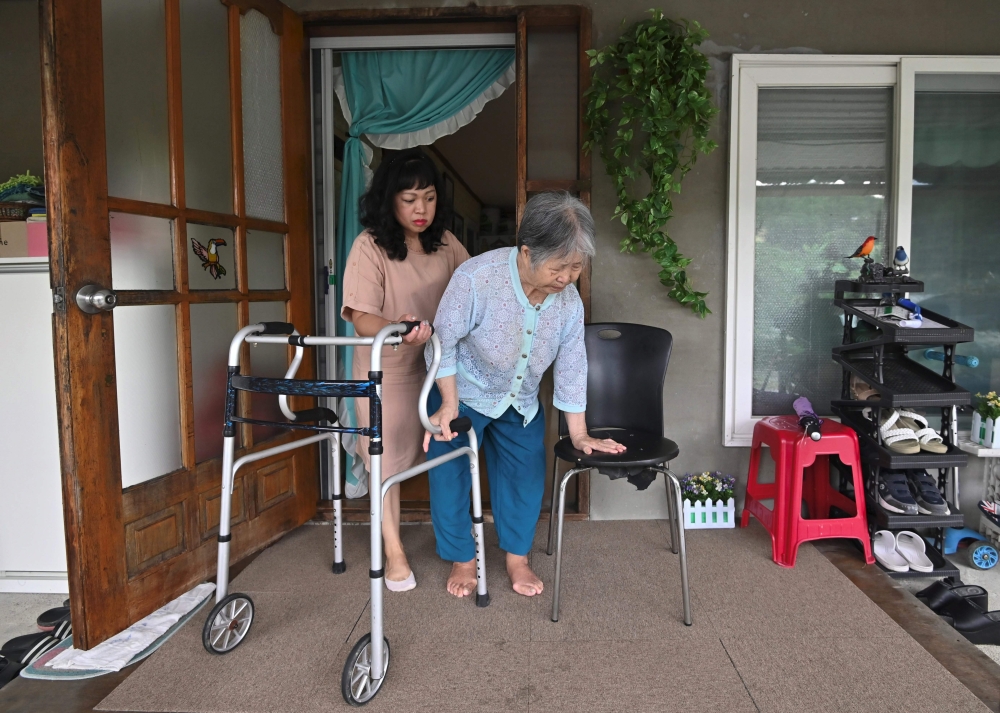 This picture taken on August 30, 2019 shows Emma Sumampong (L) helping her mother-in-law Kim Geum-nyeo (R) during an interview with AFP at her house in the mountainous town of Hoengseong. AFP / Jung Yeon-je