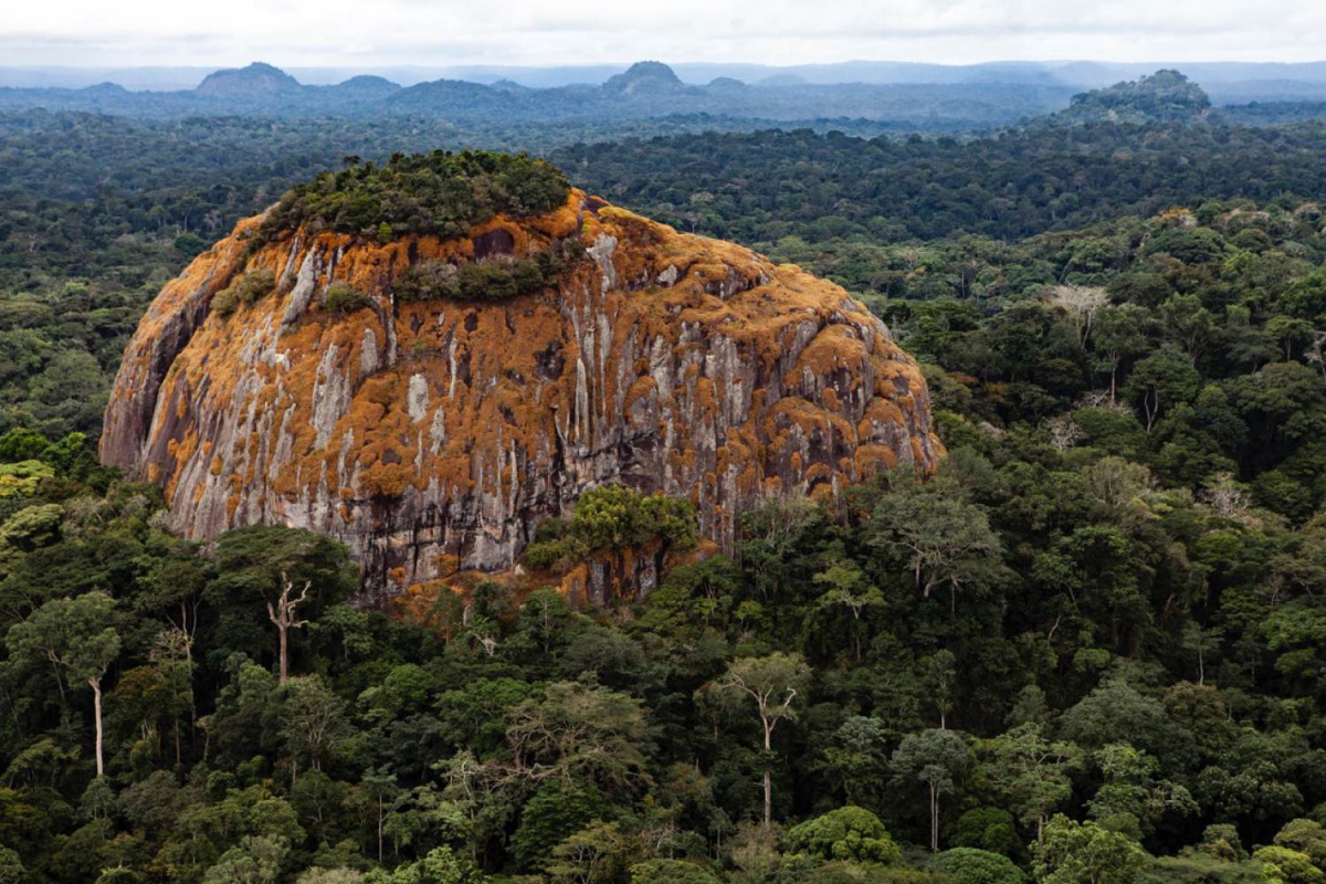 A large rock juts out from the tropical rainforest in the central African country of Gabon, 23 August 2012. Josh Ponte/Handout via Thomson Reuters Foundation