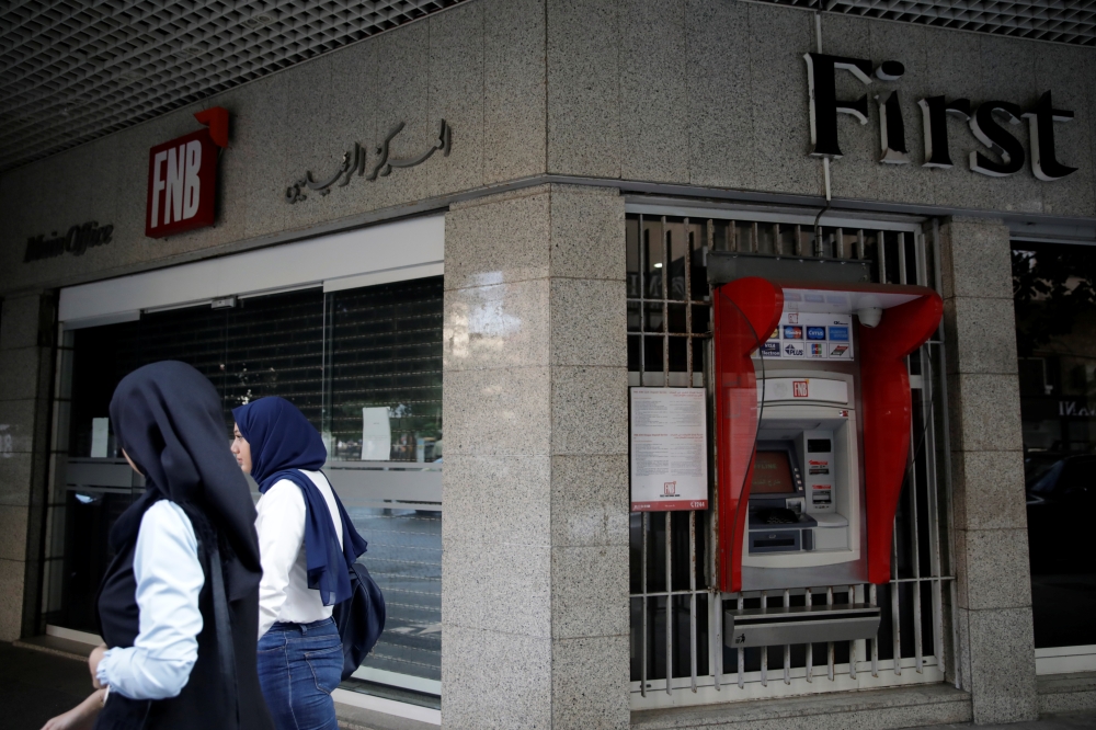 Two women walk past a closed bank office in Beirut, Lebanon November 15, 2019. Reuters/Andres Martinez Casares
 