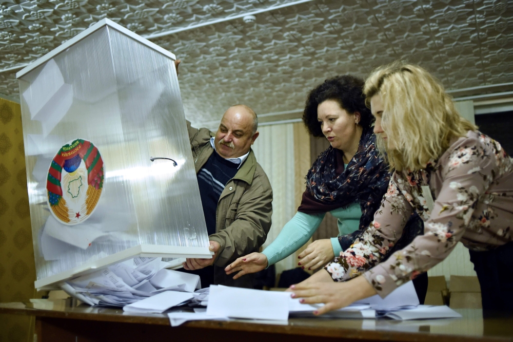 Local electoral commission members empty a ballot box to count votes at a polling station in the village of Kreva, some 10 km northwest of Minsk, on November 17, 2019. AFP / Sergei Gapon 