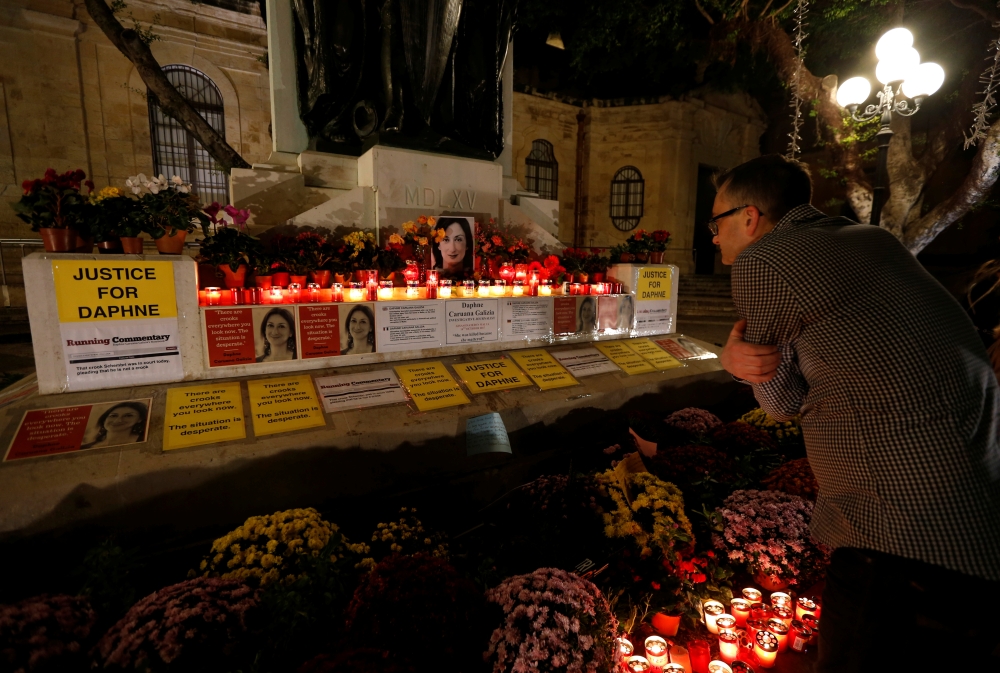 A tourist looks at a makeshift memorial to assassinated anti-corruption journalist Daphne Caruana Galizia after an anti-corruption protest against the government of Prime Minister Joseph Muscat in Valletta, Malta, November 16, 2019. REUTERS/Darrin Zammit 