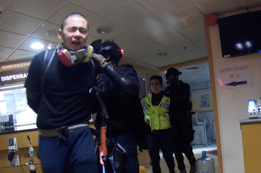 Riot police detain a protester and a medic during pre-dawn police operations at Hong Kong Polytechnic University (PolyU), Hong Kong, China November 18, 2019, in this still image obtained from a social media video. PolyU Campus Radio/via Reuters