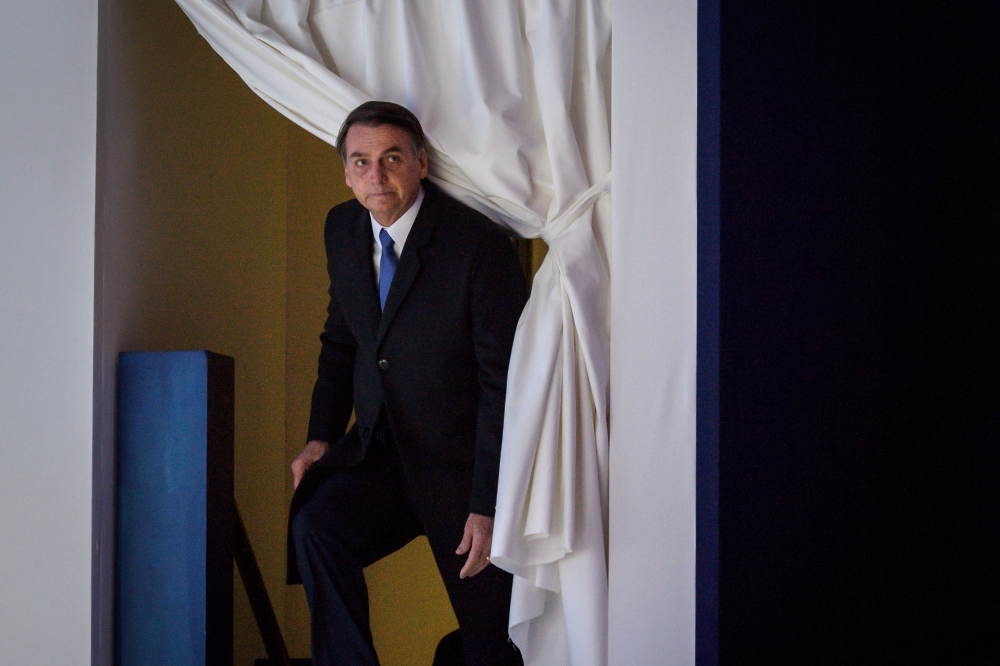 Brazilian President Jair Bolsonaro enters the stage prior to deliver a speech during the World Economic Forum annual meeting on January 22, 2019 in Davos. AFP / Fabrice Coffrini