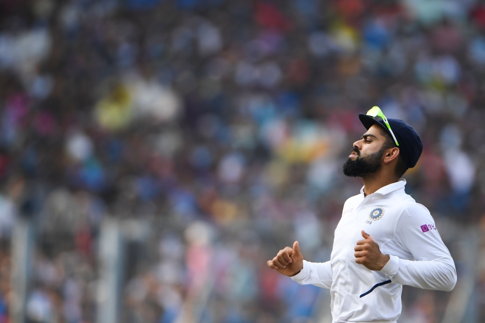 India's cricket team captain Virat Kohli runs to field a ball during the first day of the second Test cricket match of a two-match series between India and Bangladesh at The Eden Gardens cricket stadium in Kolkata on November 22, 2019. / AFP / Dibyangshu 