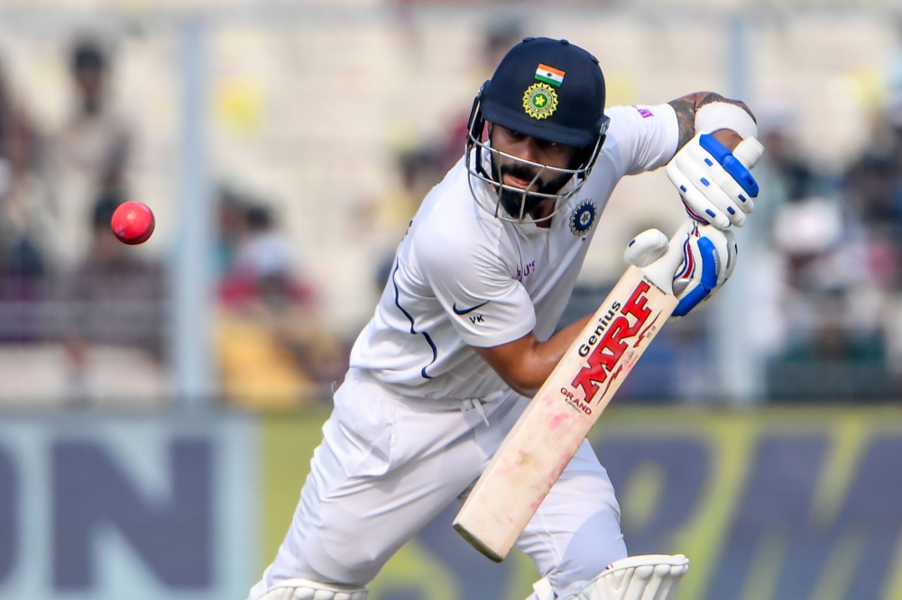 India's captain Virat Kohli plays a shot during the second day of the second Test cricket match of a two-match series between India and Bangladesh at the Eden Gardens cricket stadium in Kolkata on November 23, 2019. (AFP / Dibyangshu SARKAR)