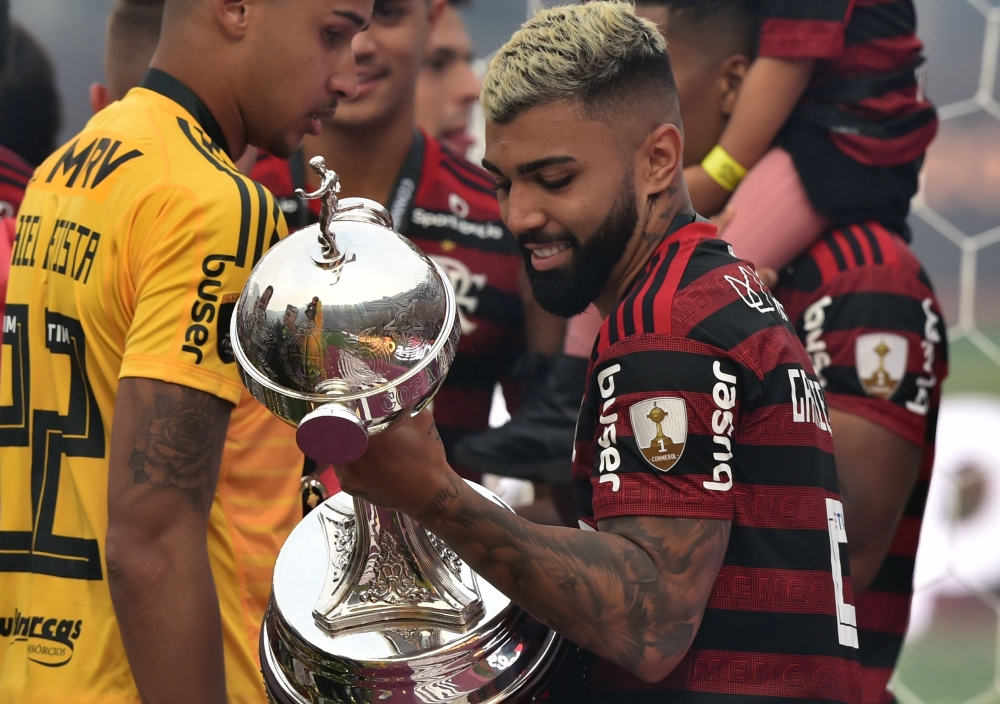 Flamengo's Gabriel Barbosa holds the trophy after winning the Copa Libertadores final football match by defeating Argentina's River Plate, at the Monumental stadium in Lima, on November 23, 2019. / AFP / CRIS BOURONCLE