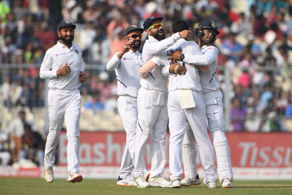 India's cricket team captain Virat Kohli (R) celebrates after winning the match during the third day of the second Test cricket match of a two-match series between India and Bangladesh at the Eden Gardens cricket stadium in Kolkata on November 24, 2019. /