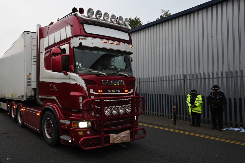 In this file photo taken on October 23, 2019 Police officers drive away a lorry in which 39 dead bodies were discovered sparking a murder investigation at Waterglade Industrial Park in Grays, east of London, on October 23, 2019. AFP / Ben STANSALL
