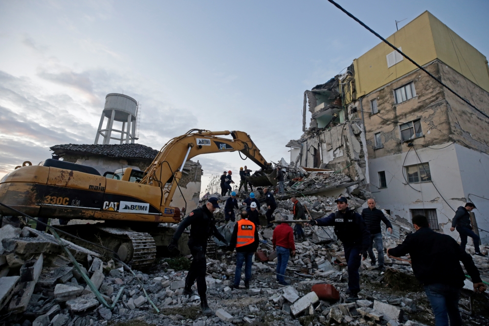 Emergency personnel work near a damaged building in Thumane, after an earthquake shook Albania, November 26, 2019. REUTERS/Florian Goga
