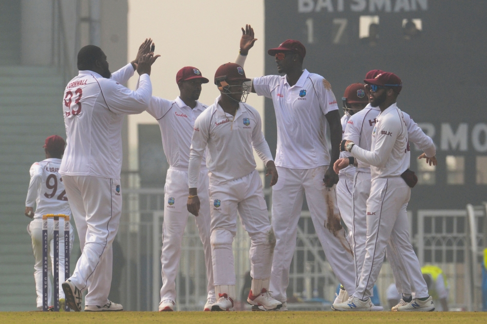 West Indies' Rahkeem Cornwall (L) celebrates with teammates after dismisssing Afghanistan's Ibrahim Zadran (not pictured) during the international Test cricket match between Afghanistan and West Indies at the Ekana Cricket Stadium in Lucknow on November 2