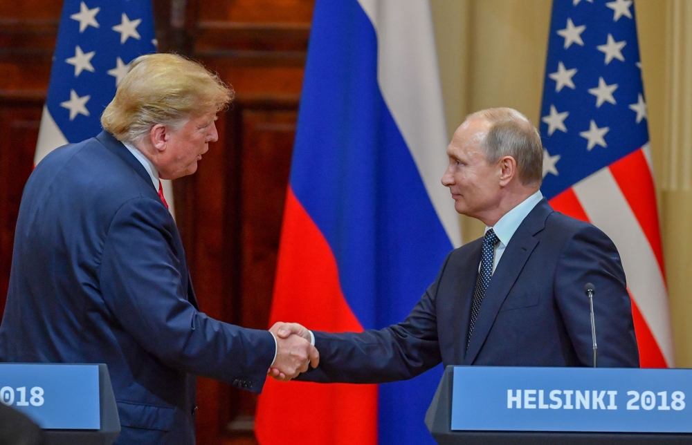 Donald Trump and Vladimir Putin shake hands before attending a joint press conference after a meeting at the Presidential Palace in Helsinki on July 16, 2018. AFP / Yuri Kadobnov