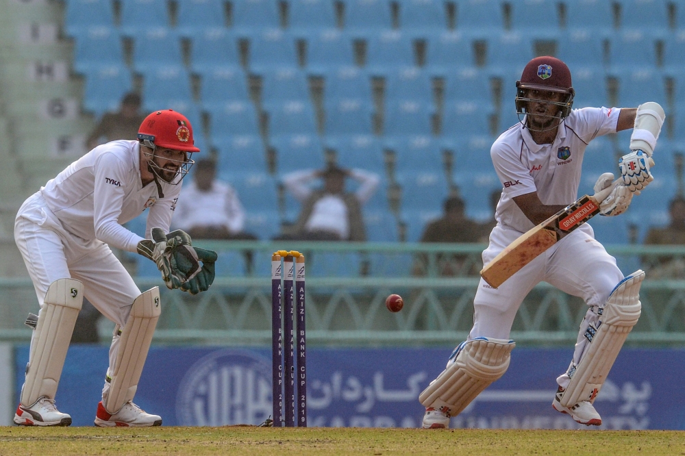West Indies' Carlos Brathwaite (R) plays a shot during the first day of an international Test cricket match between Afghanistan and West Indies at the Ekana Cricket Stadium in Lucknow on November 27, 2019. IMAGE RESTRICTED TO EDITORIAL USE - STRICTLY NO C
