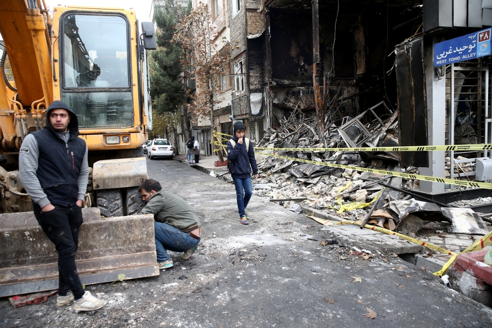 File photo of people walk near a burnt bank, after protests against increased fuel prices, in Tehran, Iran November 20, 2019.  Nazanin Tabatabaee/WANA (West Asia News Agency) via REUTERS 
 