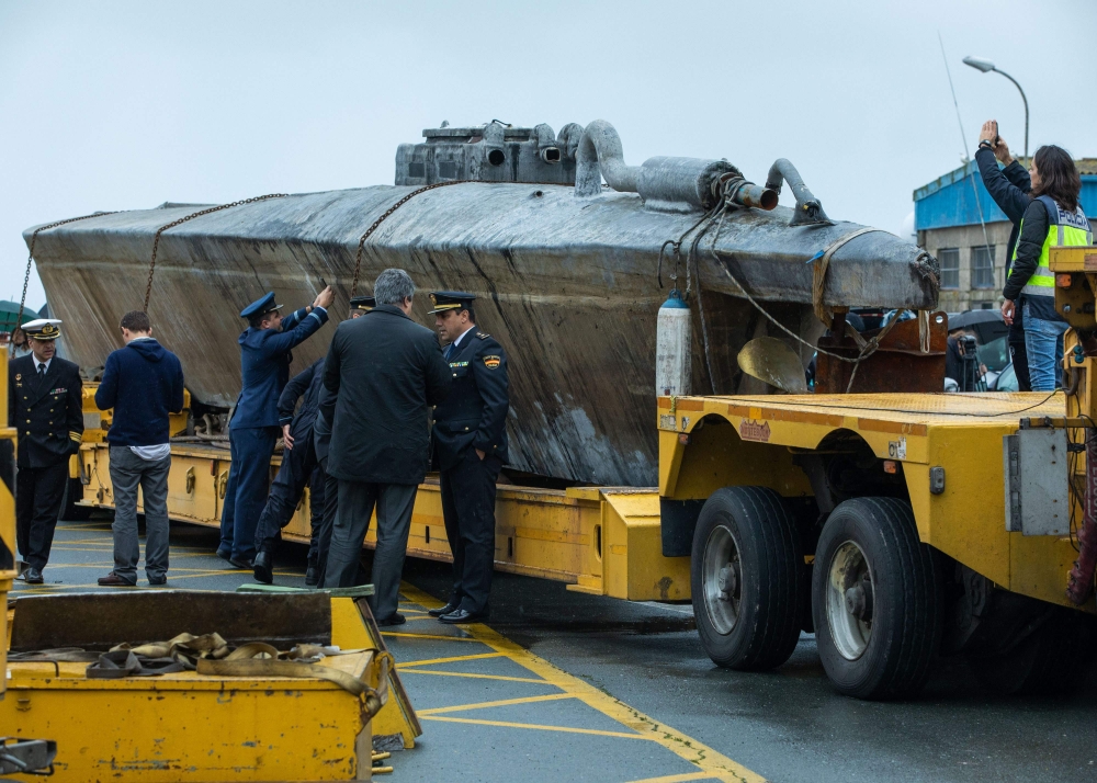 Official stand near a submarine used to transport drugs illegally in Aldan, northwestern Spain, on November 27, 2019.  AFP / Lalo R. VILLAR