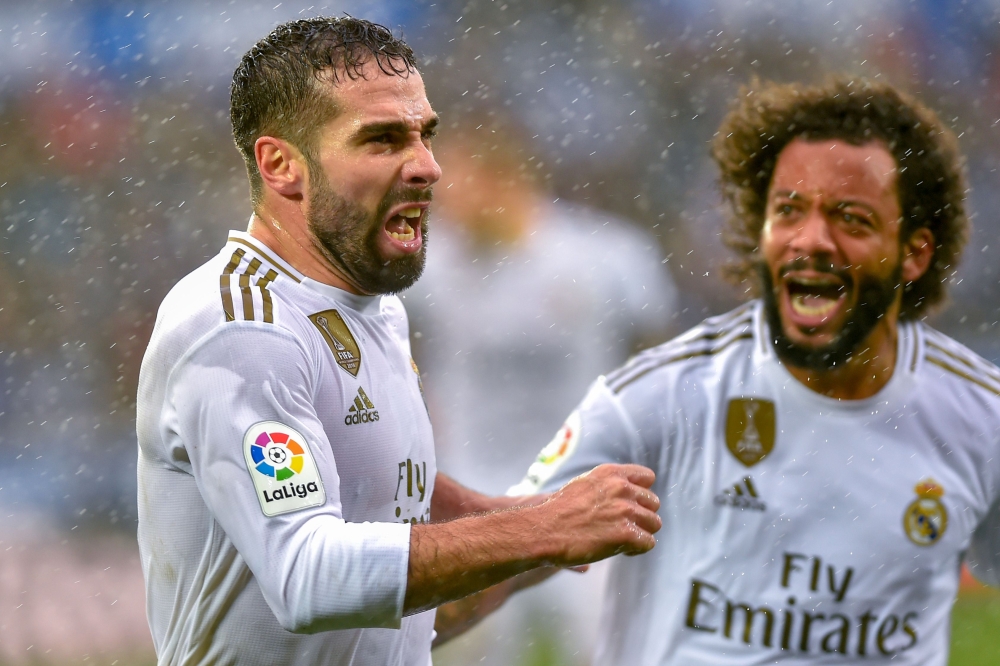 Real Madrid's Spanish defender Daniel Carvajal (L) celebrates after scoring a goal during the Spanish league football match between Deportivo Alaves and Real Madrid CF at the Mendizorroza stadium in Vitoria on November 30, 2019. / AFP / ANDER GILLENEA