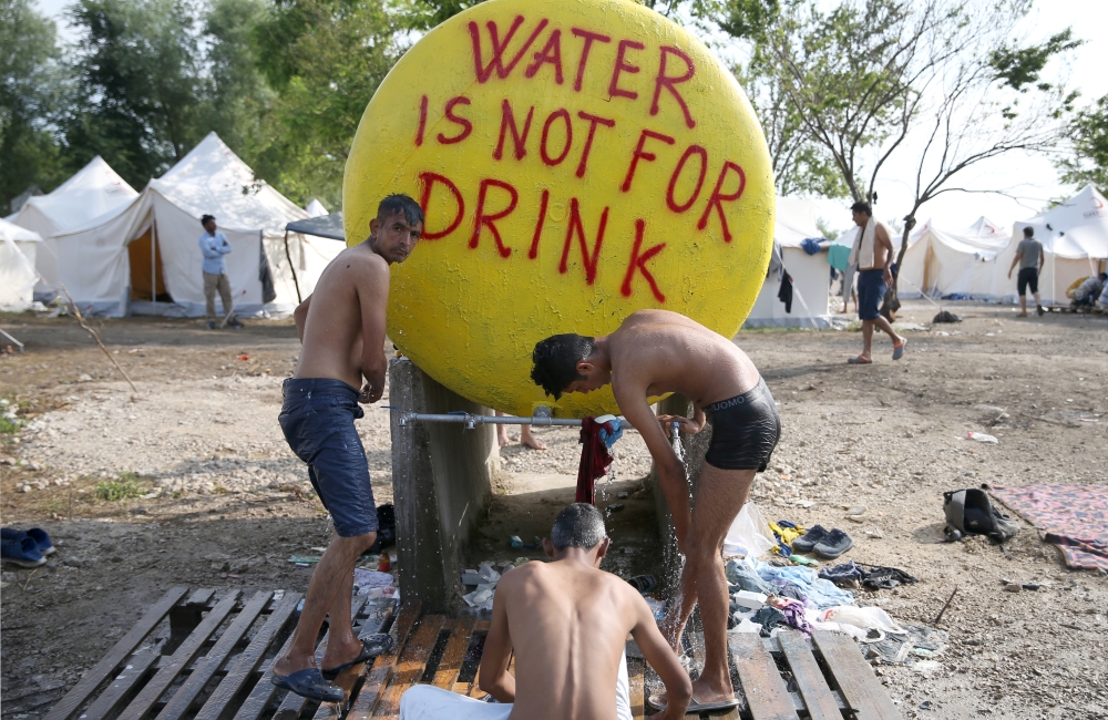 Migrants take a shower in camp Vucjak in Bihac, Bosnia and Herzegovina, June 26, 2019. Reuters / Dado Ruvic