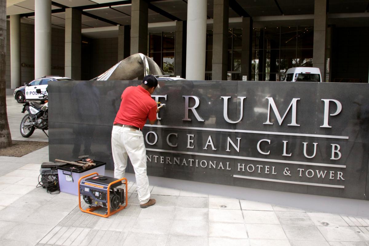 A worker removes the Trump name from the Trump Ocean Club International Hotel and Tower in Panama City, March 5, 2018. Reuters / Carlos Lemos