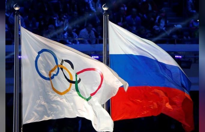 The Russian national flag (R) and the Olympic flag are seen during the closing ceremony for the 2014 Sochi Winter Olympics, Russia, February 23, 2014. REUTERS/Jim Young/File Photo