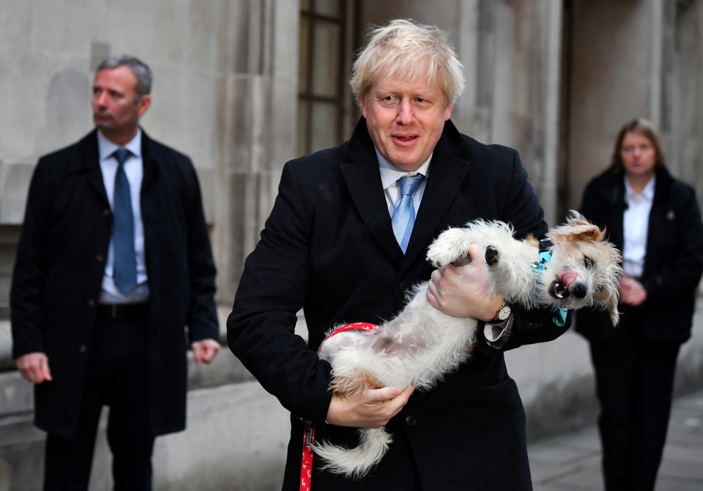 Boris Johnson holds his dog Dilyn as he leaves a polling station, at the Methodist Central Hall, after voting in the general election in London, Britain, December 12, 2019. Reuters/Dylan Martinez