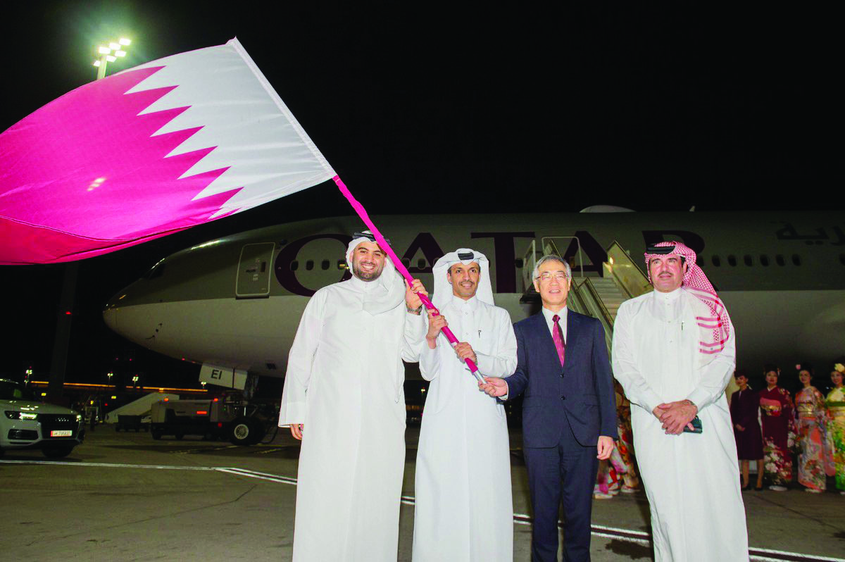 Jassim bin Rashid Al Buenain, Secretary-General of the Qatar Olympic Committee, holding the national flag with officials at the Hamad International Airport yesterday, before hanging the same to a Qatar Airways pilot to be flown to Tokyo where the 2020 Sum