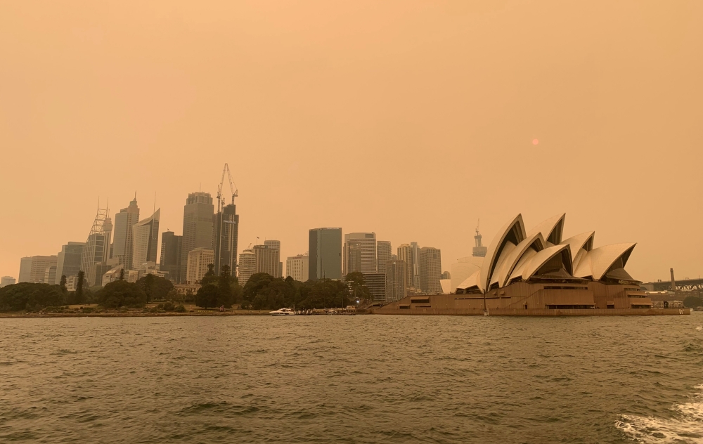 The haze from bushfires obscures the sun setting above the Sydney Opera House in Sydney, Australia, December 6, 2019. Reuters/John Mair