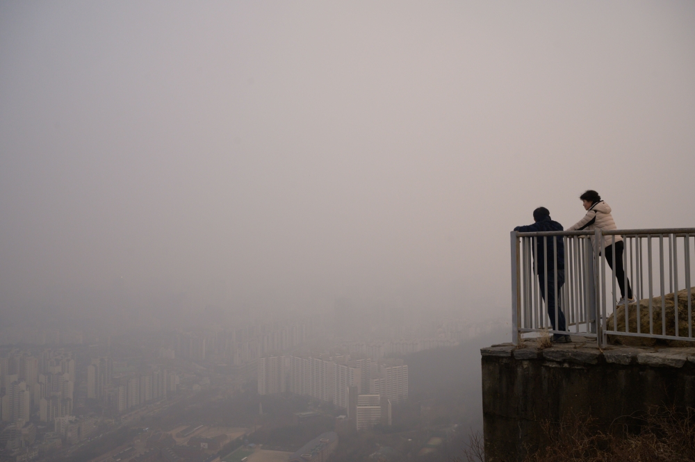 Image used for representation. Hikers stand at a viewpoint overlooking the city skyline shrouded in smog during heavily polluted weather conditions in Seoul on December 10, 2019.  / AFP / Ed JONES 