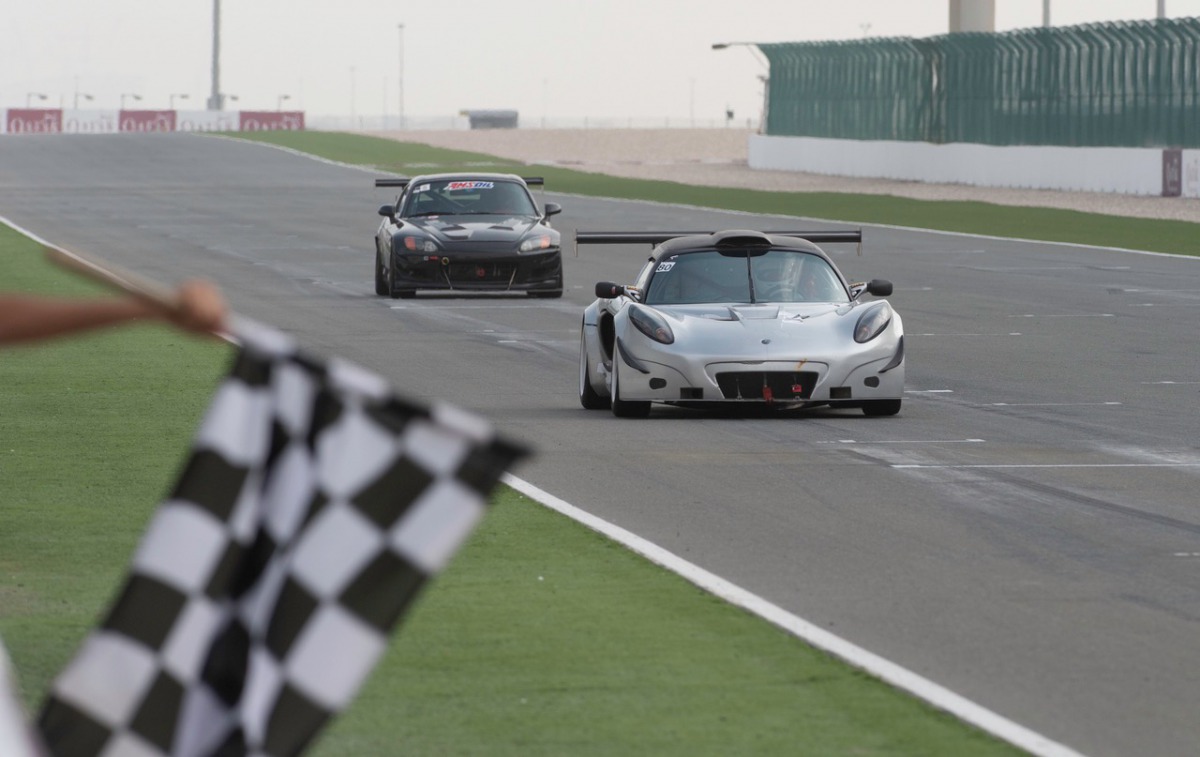 Ibrahim Al Abdulgahni (right) taking  the chequered flag to win Race 2 of the opening round of the Qatar Touring Car Championship at Losail International Circuit.