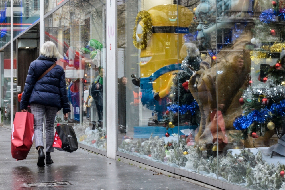 :A woman passes by the windowshop of a toys store in Paris on December 16, 2019. / AFP / Aurore MESENGE
