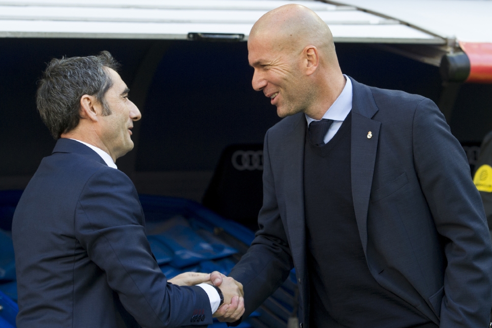 Barcelona's Spanish coach Ernesto Valverde (L) shakes hands with Real Madrid's French coach Zinedine Zidane. Madrid. December 23, 2017 / AFP / CURTO DE LA TORRE
