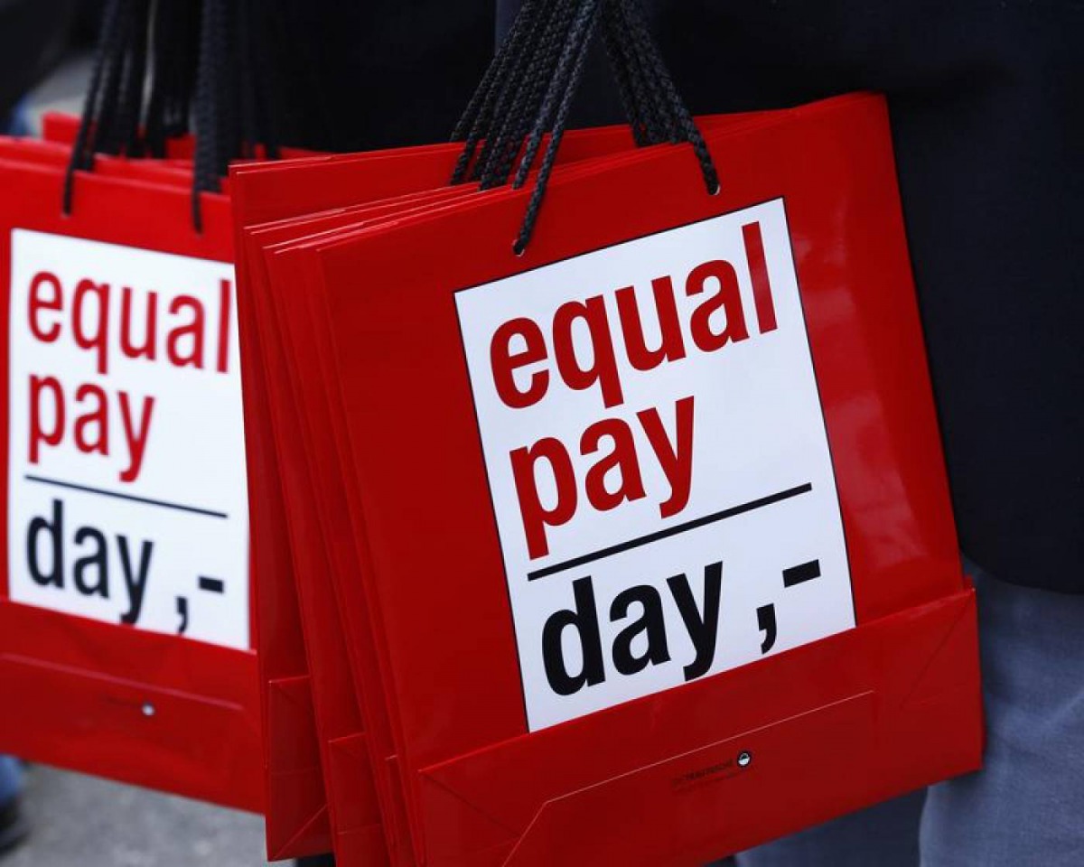 People carry bags reading 'equal pay day' during a protest a day before International Women's Day, in Bern March 7, 2015. Reuters/Ruben Sprich