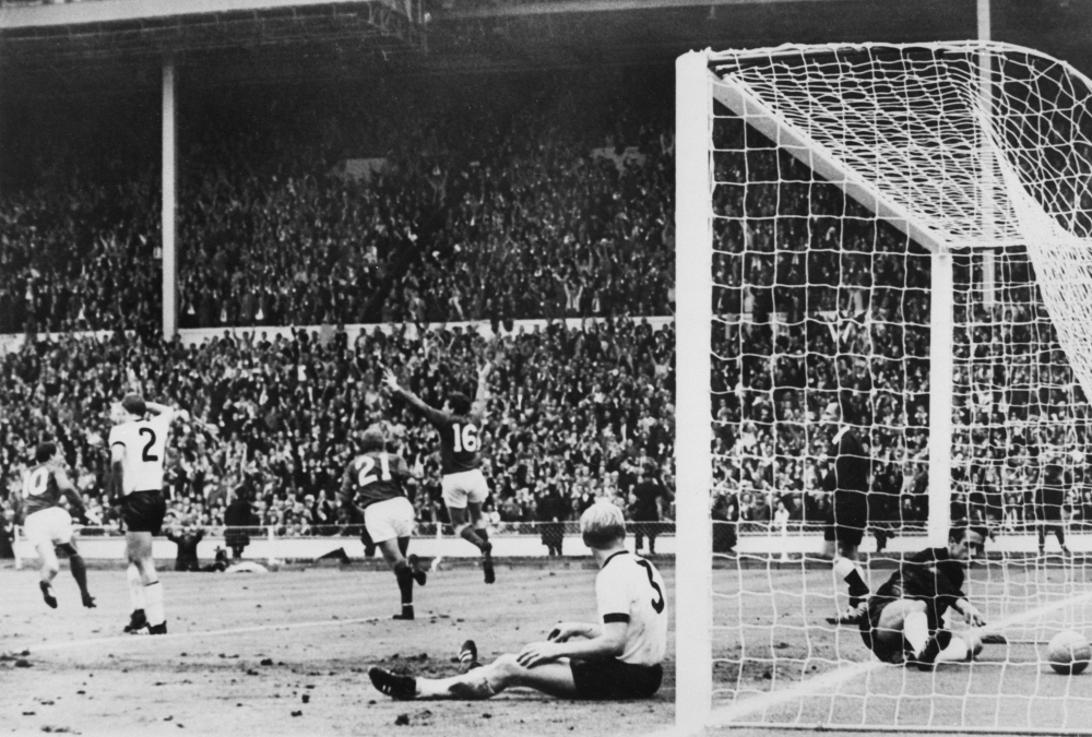 England's forward Martin Peters (16), followed by his teammate Roger Hunt, celebrates after scoring during the World Cup final. London. July 30, 1966. / AFP / STRINGER
