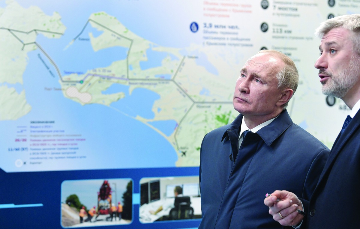Russian President Vladimir Putin (C) listens to Transport Minister Yevgeny Ditrikh after the opening ceremony of the railway part of the Crimean Bridge, connecting Crimea to mainland Russia in Taman on December 23, 2019. AFP / Sputnik / Alexey Nikolsky
