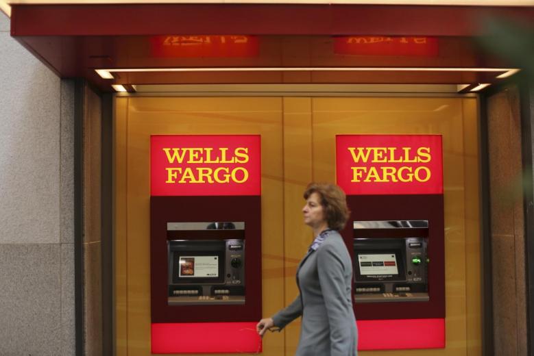 A woman walks past teller machines at a Wells Fargo bank in San Francisco in this October 10, 2013 file photo. Reuters / Robert Galbraith