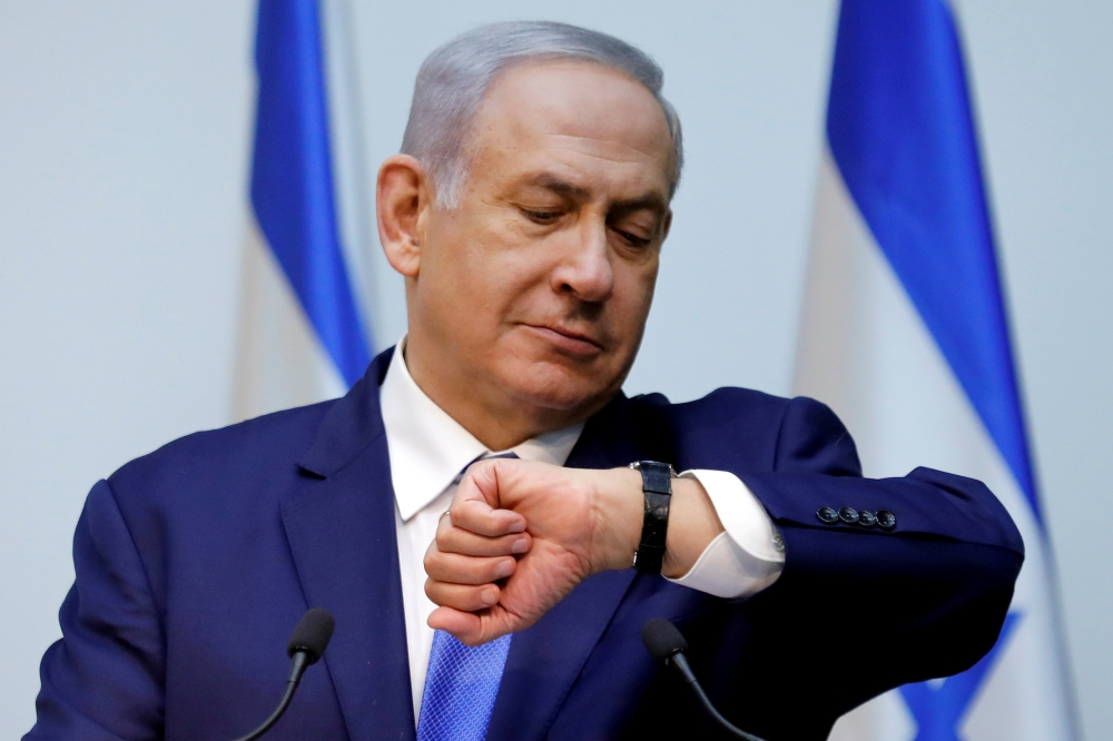 Israeli Prime Minister Benjamin Netanyahu looks at his watch before delivering a statement at the Knesset, Israeli parliament, in Jerusalem. December 19, 2018. Reuters / Amir Cohen