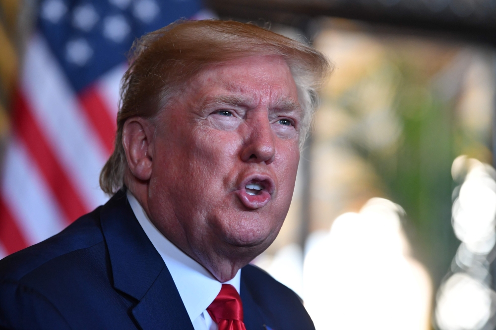 In this file photo taken on December 24, 2019 US President Donald Trump answers questions from reporters after making a video call to the troops stationed worldwide at the Mar-a-Lago estate in Palm Beach Florida