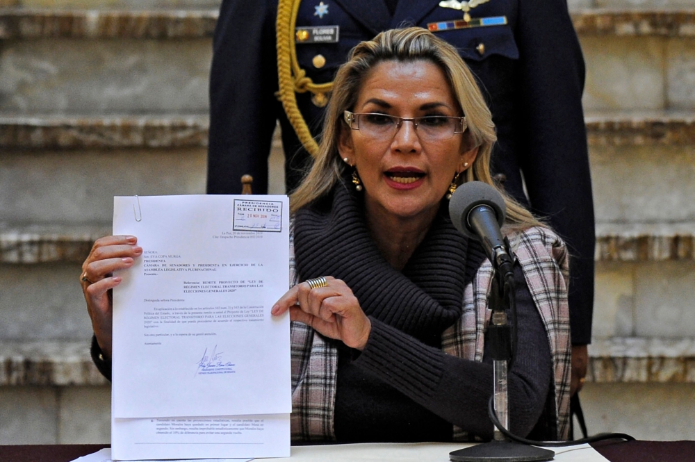 Bolivian interim President Jeanine Anez shows a document as she presents a bill on the Transition Electoral Regime for the 2020 general elections in La Paz on November 20, 2019. AFP / Jorge Bernal