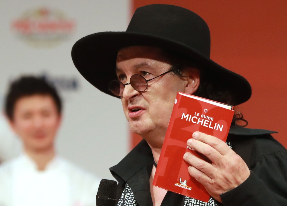 French chef Marc Veyrat, holds a Michelin guide after being awarded the maximum three Michelin stars, during the Michelin guide award ceremony at La Seine Musicale in Boulogne-Billancourt near Paris, on February 05, 2018. AFP / Jacques Demarthon
 
 
