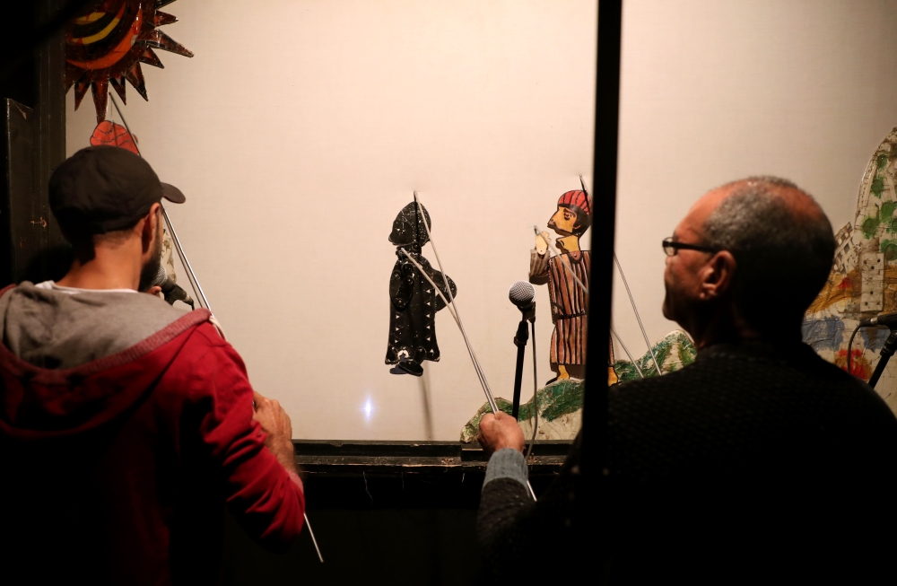 Members of Egypt's Wamda troupe manipulate puppets during a Aragoz puppets show in Beit al-Sehemi, in Cairo's Gamaliya district, on November 15, 2019.  AFP / Mohamed el-Shahed 