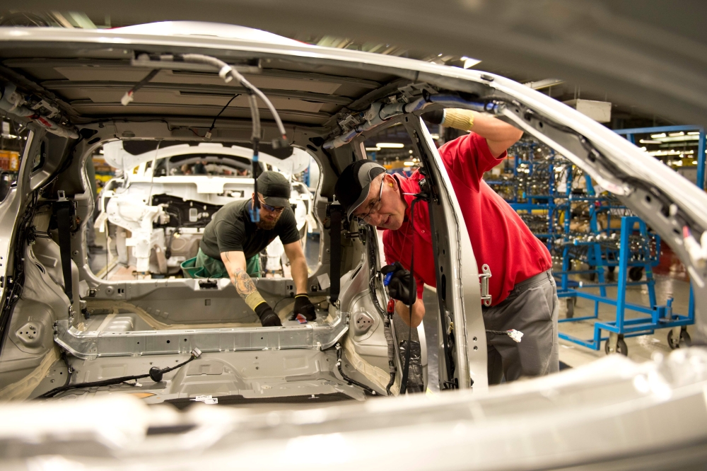 Nissan manufacturing staff works in the Trim and Chassis section of their Sunderland Plant in north east England on November 12, 2014. AFP / Oli Scarff
