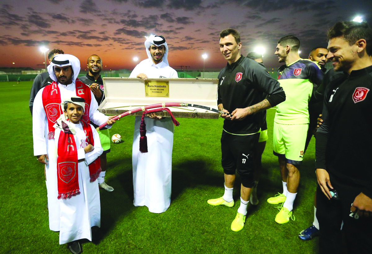 An Al Duhail fan presenting a sword as a welcoming gift to Mario Mandzukic during a training session in Doha yesterday.