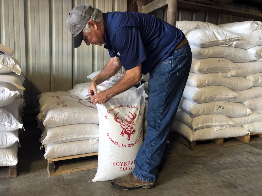Raymond Schexnayder Jr, a soybean farmer, closes a bag of soybeans from his farm outside Baton Rouge in Erwinville, Louisiana, July 9, 2018. Reuters / Aleksandra Michalska