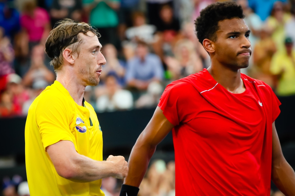 John Millman of Australia (L) shakes hands with Felix Auger-Aliassime of Canada (R) following his victory in their men's singles match on day three of the ATP Cup tennis tournament in Brisbane on January 5, 2020./ AFP / AFP / Patrick HAMILTON /