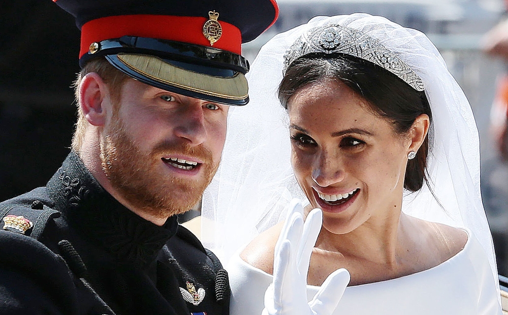 Britain's Prince Harry, Duke of Sussex and his wife Meghan, Duchess of Sussex wave from the Ascot Landau Carriage during their carriage procession on the Long Walk as they head back towards Windsor Castle in Windsor, after their wedding ceremony, May 19, 