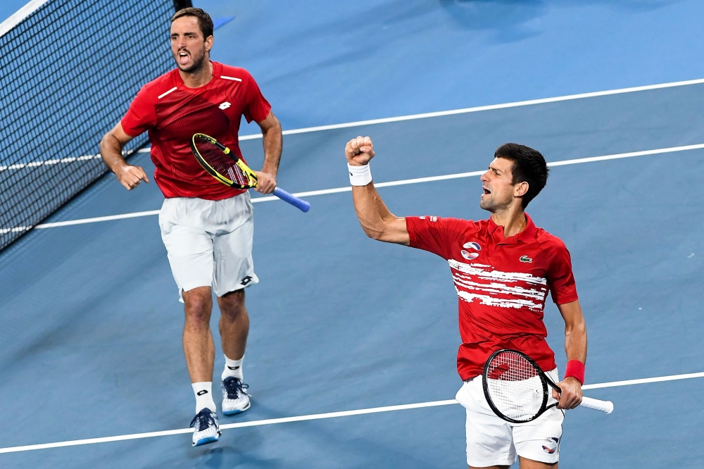 Viktor Troicki (L) and Novak Djokovic (R) of Serbia celebrate winning the first set in their men's doubles match against Pablo Carreno Busta and Feliciano Lopez of Spain in the final of the ATP Cup tennis tournament in Sydney on January 13, 2020.  AFP / W