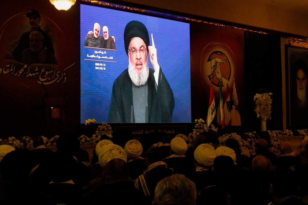 Supporters of the the Shiite Hezbollah movement watch as the movement's leader Hasan Nasrallah delivers a speech on a screen in the southern Lebanese city of Nabatieh on January 12, 2020. AFP / Mahmoud Zayyat
 
 