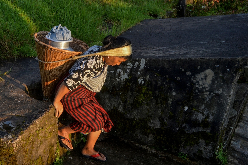 A woman carrying a bucket after collecting drinking water from a steam at Nongthymmai-Lumthangding village on the outskirts of Shillong in Meghalaya September 19, 2019. AFP / Diptendu Dutta 